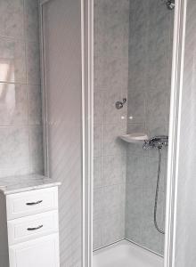 baño con ducha y puerta de cristal en St.Flórián Apartman en Keszthely