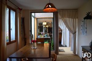 uma sala de jantar com uma mesa e um corredor com uma cozinha em La Freneraie em Paulhac