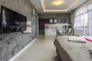 a bedroom with a bed and a table and a kitchen at Apartamenty hoteLOVE na Skale in Karpacz