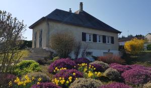 an old house with a garden of flowers at LA MAISON DU MUGUET - Accueil Chevaux - Horse Friendly in Liart