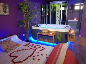 a bedroom with a tub and a bed with red flowers at Lov'appart in Boulogne-sur-Mer