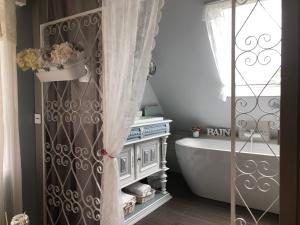 a bathroom with a bath tub and a sink at Gite Riquewihr "C'est Beau la Vie Alsace" in Riquewihr