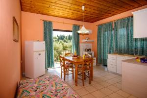a kitchen and dining room with a table and a dining room at Dionysia's Apartments in Tsilivi