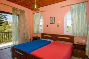 a bedroom with two beds and a balcony at Dionysia's Apartments in Tsilivi