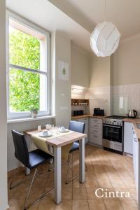 une cuisine avec une table et des chaises dans l'établissement Brokilon House, à Cracovie