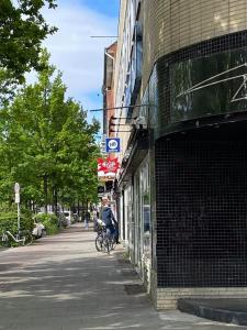 uma pessoa a andar de bicicleta numa rua ao lado de um edifício em instantSleep Backpackerhostel St Pauli em Hamburgo