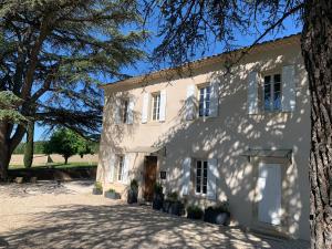 a white house with a tree in front of it at LE MAS AUX CEDRES - Teritoria in Lioux