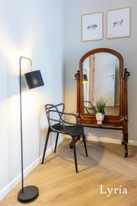 Cette chambre comprend une chaise et un miroir. dans l'établissement Brokilon House, à Cracovie
