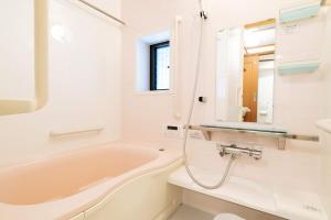 a bathroom with a tub and a sink at Casaya TABI-NE in Kanazawa