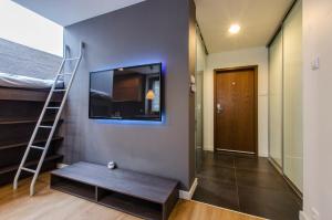 a room with a staircase and a tv on a wall at LupoApartments Kosynierów Klimatyzacja Dostęp na Kod in Łódź