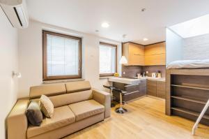 a living room with a couch and a kitchen at LupoApartments Kosynierów Klimatyzacja Dostęp na Kod in Łódź