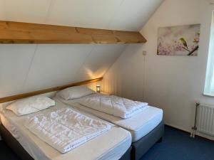 een slaapkamer met 2 bedden op een zolder bij Oesterbaai 35 in Wemeldinge