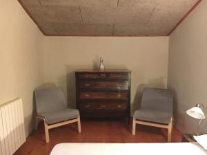 twee stoelen naast een dressoir in een slaapkamer bij Cal Pai in Pardines