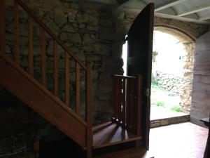 een open houten trap in een stenen gebouw met een deur bij Cal Pai in Pardines