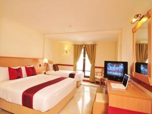 una camera d'albergo con due letti e una televisione di The Ecotel Bangkok a Bangkok