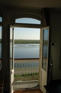 eine Tür zu einem Zimmer mit Blick auf das Wasser in der Unterkunft Vue exceptionnelle sur la Baie de Somme in Saint-Valery-sur-Somme