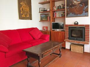 a living room with a red couch and a tv at Scoiattolo in Bardonecchia