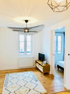 una camera con letto e lampadario a braccio di Appartement Plage Calme Centre 4personnes St Jean de Luz a Saint-Jean-de-Luz