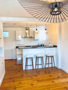 una cucina con isola-cucina con sgabelli da bar di Appartement Plage Calme Centre 4personnes St Jean de Luz a Saint-Jean-de-Luz
