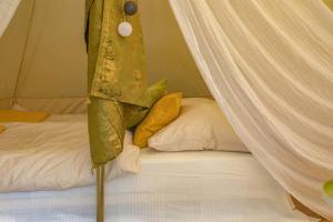a bed with a canopy and pillows in a room at Into the Green Glamping - Chestnut in Markt Nordheim