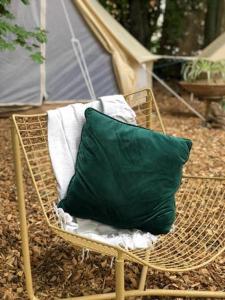 a green pillow sitting on a chair with a tent at Into the Green Glamping - Chestnut in Markt Nordheim +4 photos