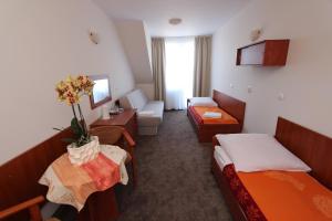 a hotel room with two beds and a table with flowers at Sunset Przymorze in Rewal