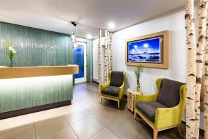 a hotel lobby with two chairs and a bar at fjord hotel berlin in Berlin