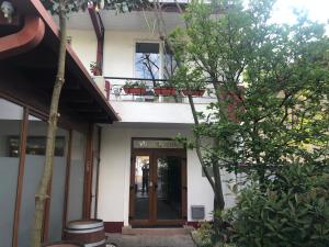 une maison avec une porte et un arbre en face de celle-ci dans l'établissement Villa Rosa, à Timişoara