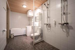 a bathroom with a shower and a toilet and a tub at Ski-Inn MastonAitio in Ruka