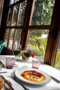 a plate of food on a table with glasses of wine at Parador de La Gomera in San Sebastián de la Gomera