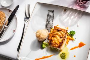 a white plate with a piece of food and broccoli at Parador de La Gomera in San Sebastián de la Gomera