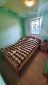 a large bed in a room with a window at Agroturystyka Domki Eden in Sarbinowo