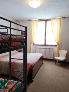 Un dormitorio con una litera y una silla. en Ca' Francesca - bilocale a Cesana Torinese, en Cesana Torinese
