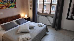 1 dormitorio con cama con almohadas y ventana en Bed & Breakfast CENTRALE, en Bolonia