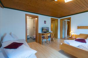a bedroom with two beds and a desk with a television at Salaterhof Embach in Lend