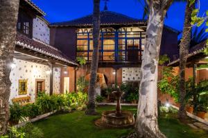 an exterior view of a house with a courtyard with a fountain at Parador de La Gomera in San Sebastián de la Gomera