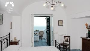 a bedroom with a bed and a dining room with a table at Al Poggio Antico in Amalfi