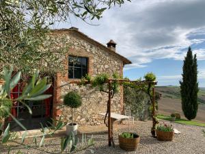 a stone house with a garden in front of it at The Lazy Olive Villa - Podere Finerri in Asciano