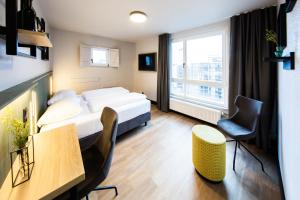 a hotel room with a bed and a table and chairs at fjord hotel berlin in Berlin
