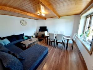 a living room with a couch and a table and chairs at Viktória- neakceptujeme mladé partie in Terchová