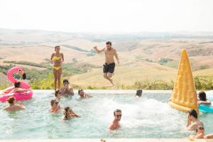 a group of people in a swimming pool with a cone at The Lazy Olive Villa - Podere Finerri in Asciano
