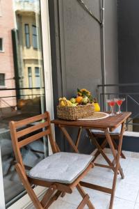 a table with a basket of fruit on a balcony at HOTEL_TIER in Athens