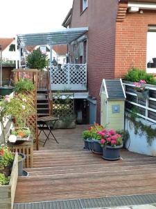 une terrasse avec des plantes en pot et une maison pour oiseaux dans l'établissement Schwalbennest_ Silke Felix, à Sierksdorf