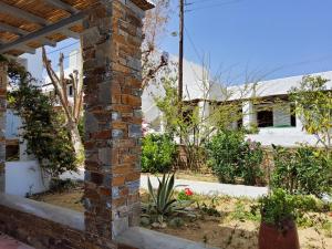 a brick column in a garden with a house in the background at Nefeli in Livadi
