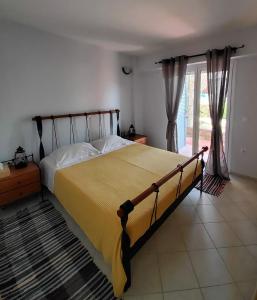 a bedroom with a large bed with a yellow blanket at Nefeli in Livadi