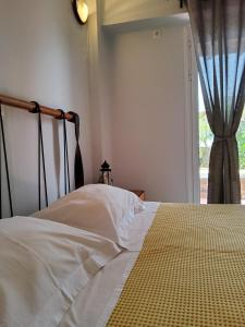 a bedroom with a white bed with a window at Nefeli in Livadi