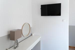 a mirror on a shelf with a tv on a wall at HOTEL_TIER in Athens