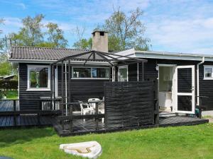 Casa negra con terraza con mesa y sillas en 6 person holiday home in Storvorde, en Storvorde
