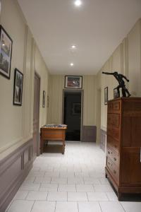 a hallway with a desk and a dresser with a horse statue on top at Chambres d'Hotes Noir Lion in Péronne