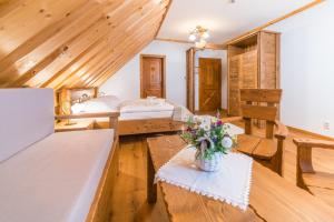 Zimmer mit 2 Betten und einem Tisch mit Blumen in der Unterkunft Salaš Syrex in Zázrivá
